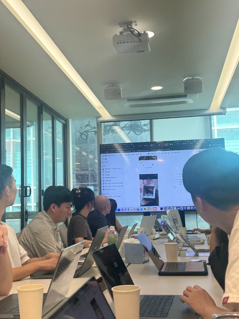 Team working session around a conference table with product boards on screen