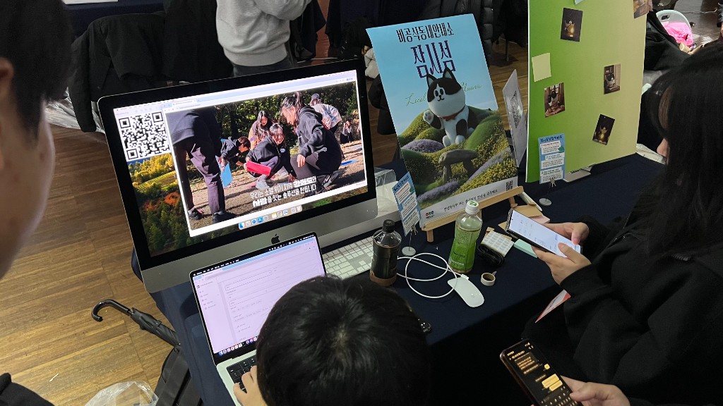 Local Universe booth with demo screens and Sunmu poster